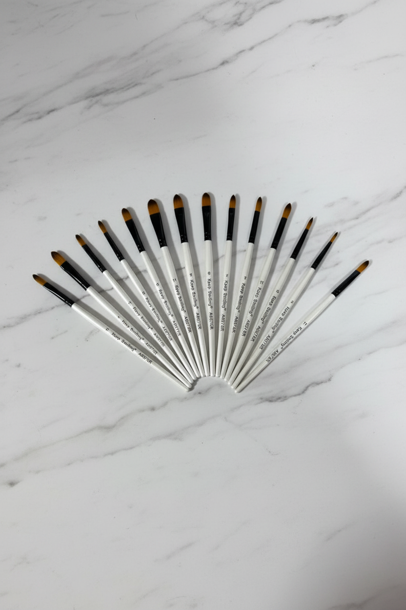 Keep Smiling artist brush set — 12 brushes fanned out, professional studio shot