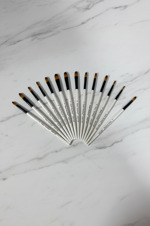 Keep Smiling artist brush set — 12 brushes fanned out, professional studio shot